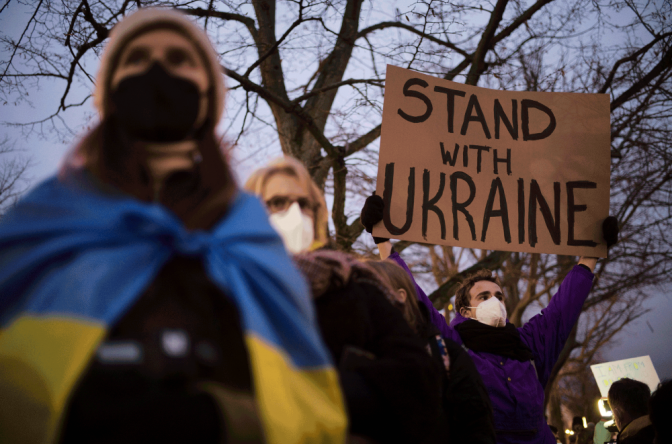 Чоловік тримає плакат на підтримку України/ Берлін, лютий 2022/Фото: Wilson Center