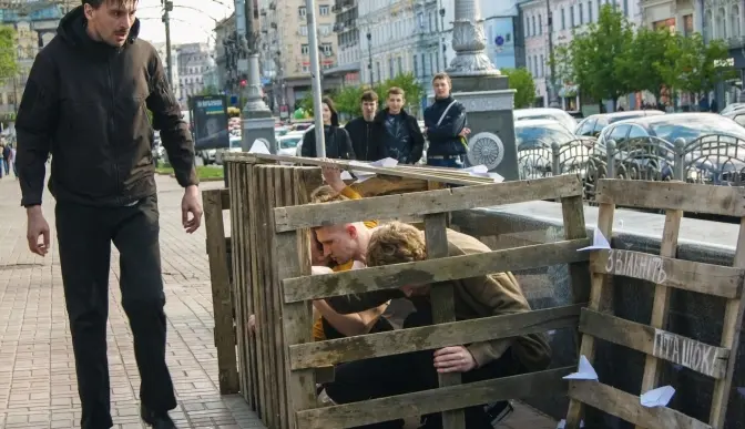 Біля переходу на Хрещатику молоді люди закрили себе в клітці задля підтримки цивільних ув'язнених