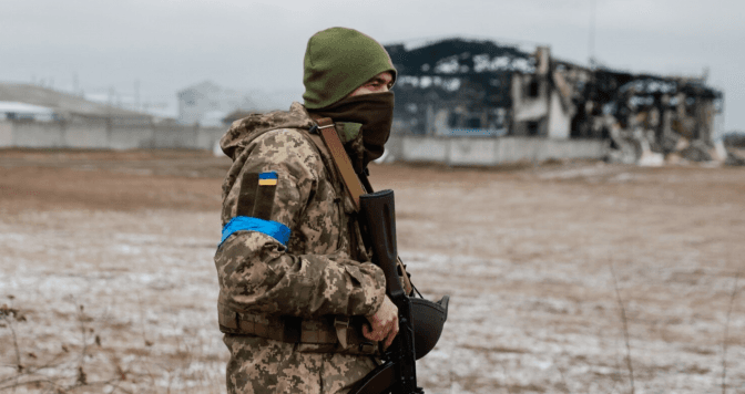 Військовий Збройних сил України біля знищеного обстрілом складського приміщення в Київській області, 13 березня 2022 року