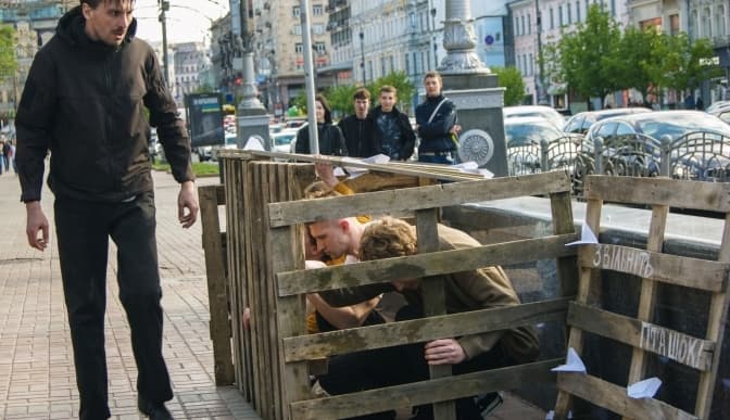 Біля переходу на Хрещатику молоді люди закрили себе в клітці задля підтримки цивільних ув'язнених