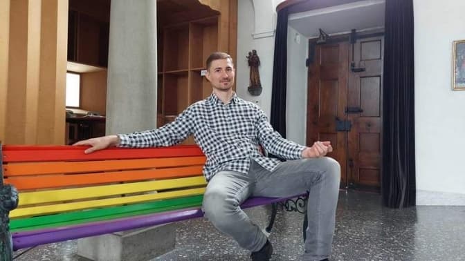 фото: о. Назар Заторський на лавці в кольорах ЛГБТ в католицькій церкві Peterskapelle в Люцерні
