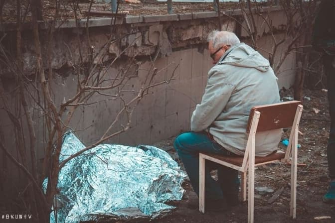 Дідусь сидить над тілом загиблої онуки. Фото: ДСНС