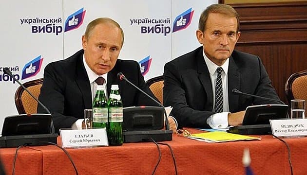 володимир путін і віктор медведчук, позаду – стенд партії "Український вибір", учасника якої 5 травня затримала СБУ