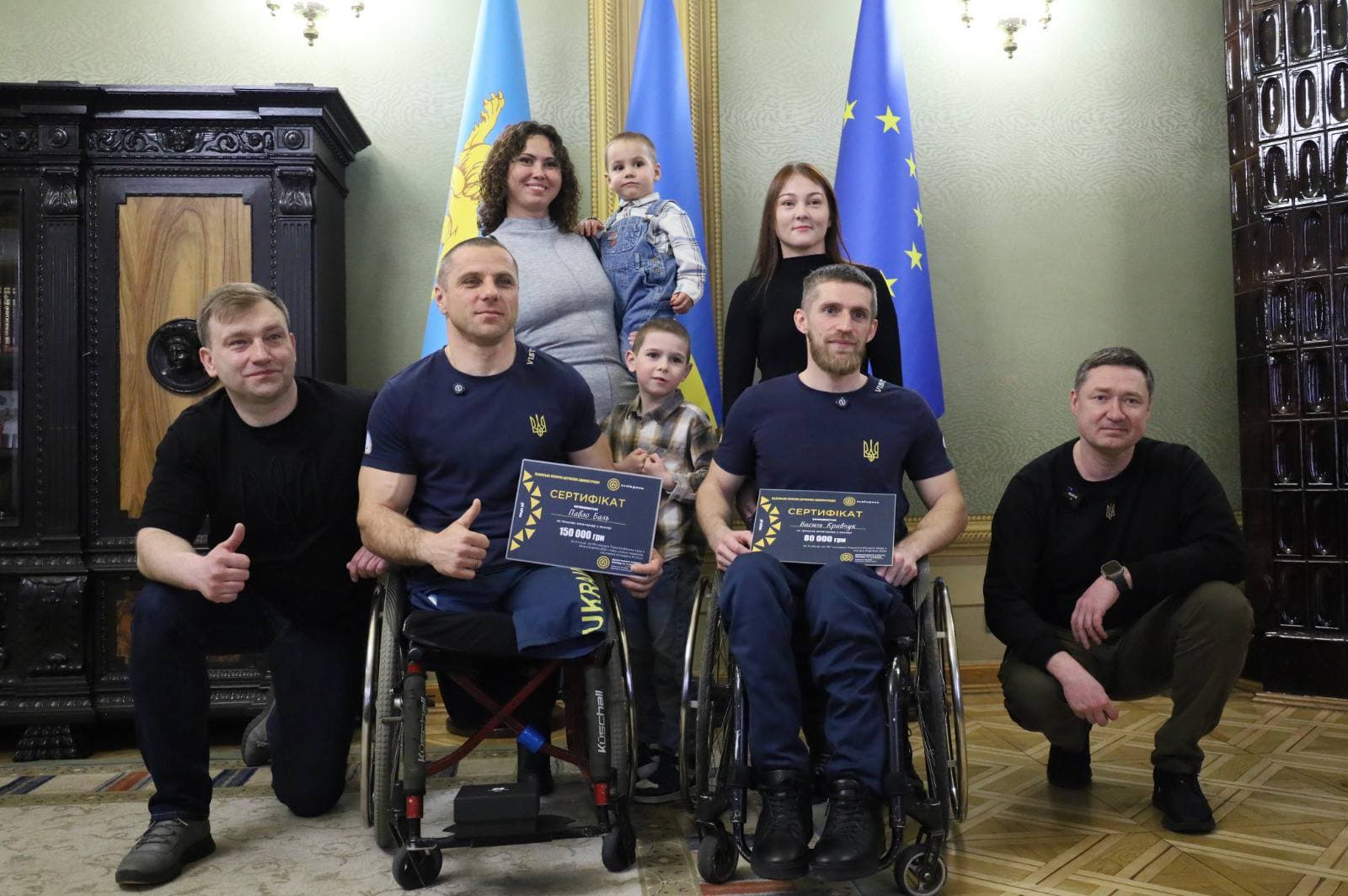 На фото паралімцпійці з родинами після привітання Максима Козицького