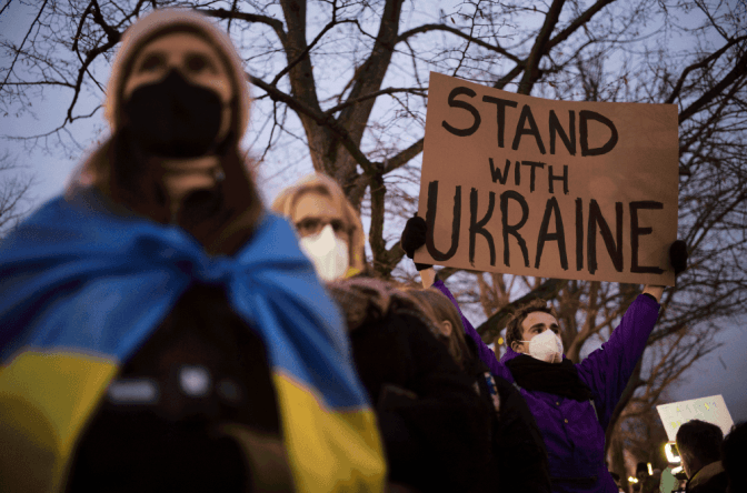 Чоловік тримає плакат на підтримку України/ Берлін, лютий 2022/Фото: Wilson Center