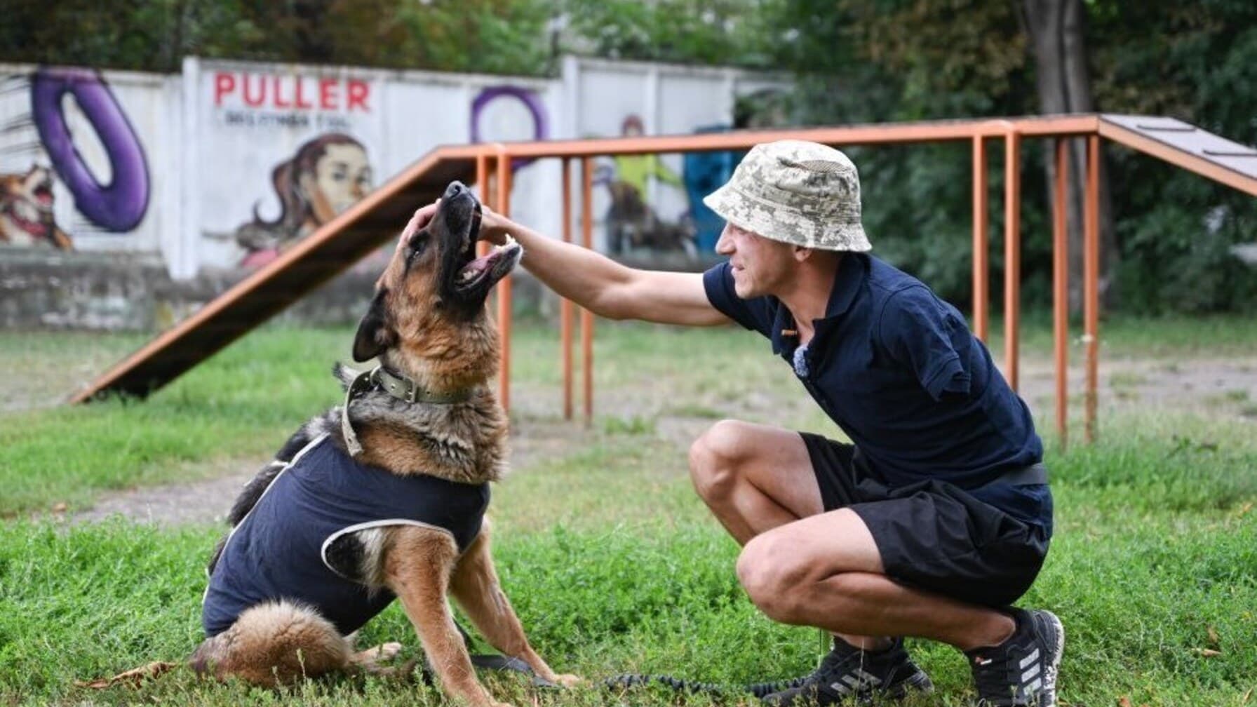 Ветеран, який втратив одну руку під час російсько-української війни, гладить собаку, породи вівчарка / фото: ЛМР