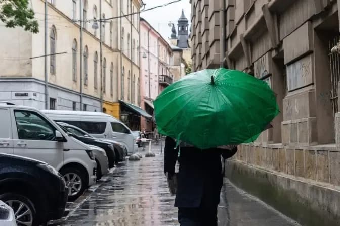 Людина під парасолею у дощ у Львові / фото: Твоє місто