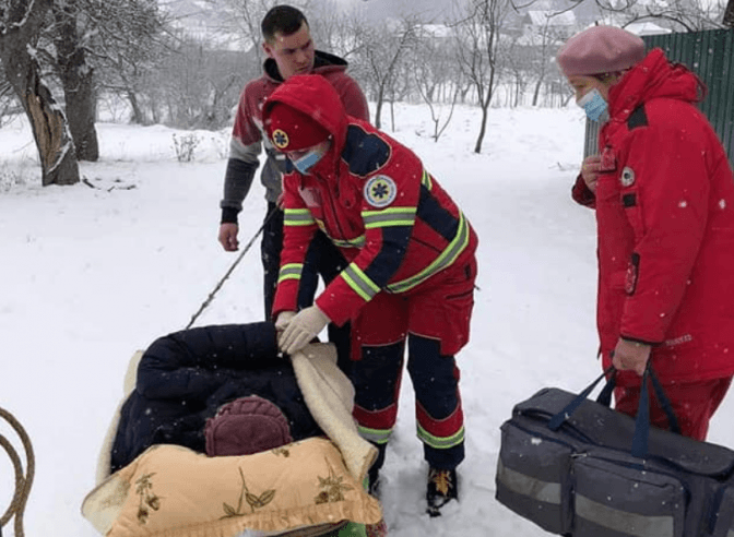 Медики через кучугури снігу завезли хвору з інфарктом на санках до «швидкої». Фото дня