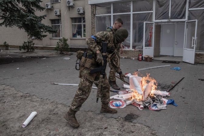 Бійці ЗСУ палять агітаційний матеріал Р*сії та «ДНР» перед мерією нещодавно деокупованого міста / Фото: Manu Brabo