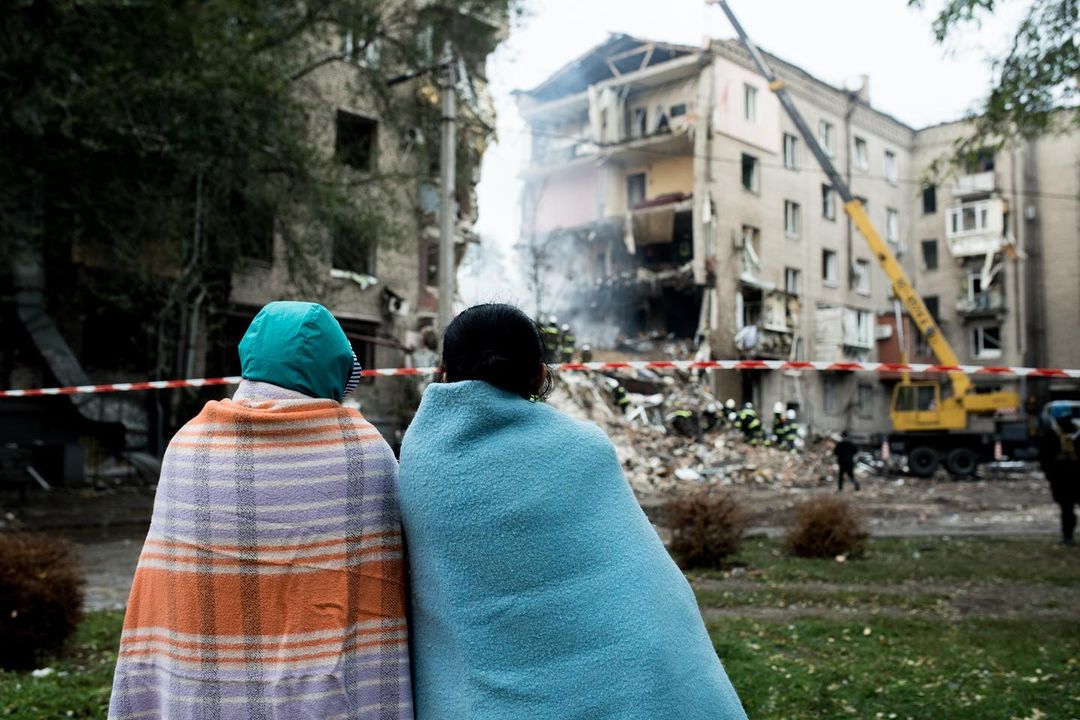 Люди перед зруйнованим унаслідок російських обстрілів будинком на Запоріжжі / Фото: Олена Тіта