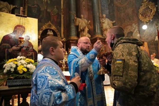 A Ukrainian soldier receives communion in the Greek Catholic Garrison Temple, a church dedicated to the military, in Lviv, western Ukraine, 1,300 km (800 miles) from the currently Russian-occupied territories in eastern Ukrainian.