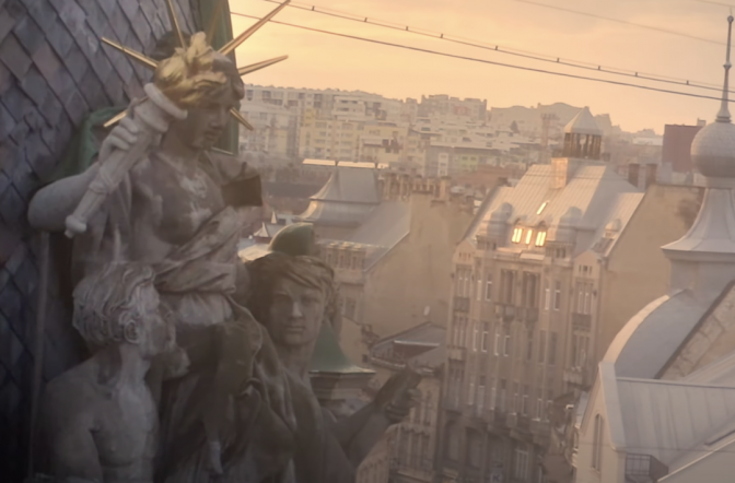 A scene of statues overlooking the Austro-Hungarian rooftops of Lviv, with Soviet buildings and the surrounding hills on the horizon, from Pavel Tymoshenko’s video «Lviv, the heart of Europe»